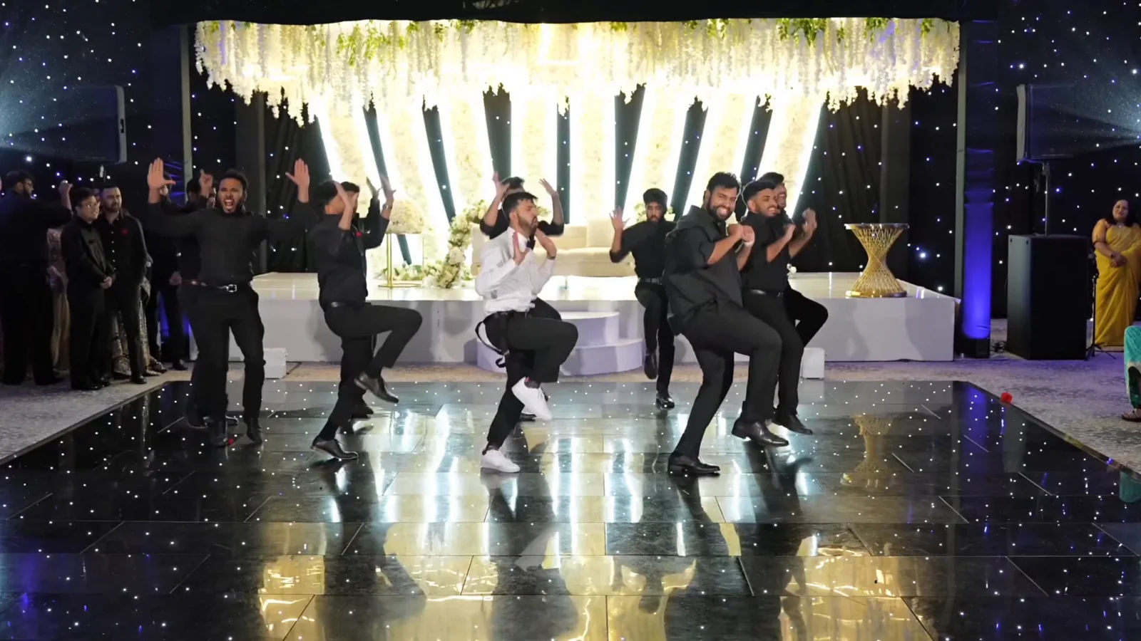 Friends and groomsmen performing a coordinated group dance